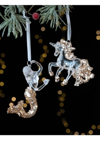 Detail of unicorn and mermaid Christmas ornaments with gold sequins on tree branch