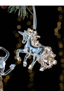 Macro shot of a transparent unicorn Christmas ornament with gold glitter details and silver string
