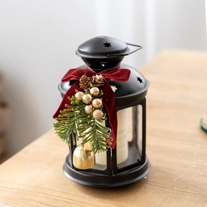 Vintage black metal Christmas lantern with red velvet bow and pine cone decorations