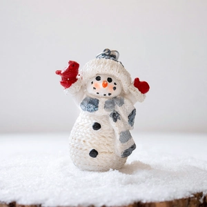 Resin snowman ornament with knitted texture, grey plaid scarf, and red bird on snowy base