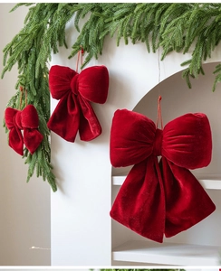 Close-up of red velvet Christmas bows in three sizes with hanging gold strings