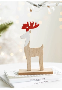 Detail of wooden Christmas reindeer ornament with red antlers on books with bokeh lights