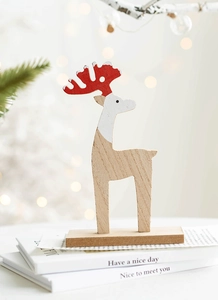Detail of wooden Christmas reindeer decor with red polka dot antlers on books