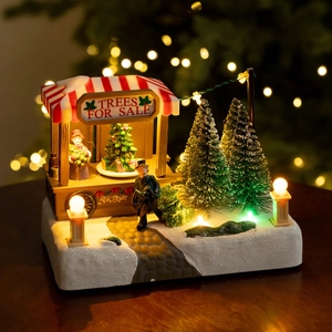 Lighted Christmas village figurine featuring a miniature tree stall and snowy LED scene