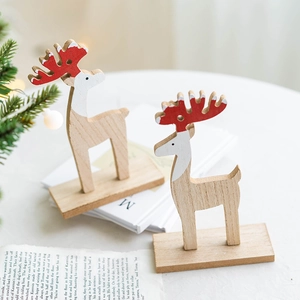 Pair of wooden Christmas reindeer ornaments with red antlers on a festive table setting