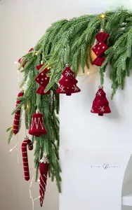 Close-up of red velvet Christmas ornaments with silver glitter patterns on pine branch