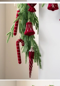 Detail of red flocked Christmas bell and candy cane ornaments on pine branches