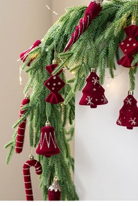 Detail of red flocked Christmas ornaments with silver glitter hanging on pine branches