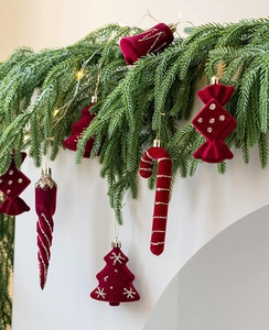 Macro detail of red flocked Christmas ornaments with silver glitter on pine branches