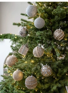 Detailed view of champagne foam Christmas ornaments with sequins and glitter on tree