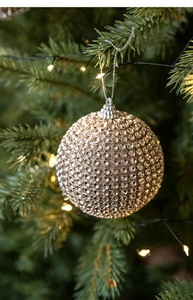 Macro shot of champagne foam Christmas ball with sparkling rhinestones on tree