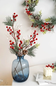 Close-up of Christmas berries and snowy pine needles in a vintage blue glass vase