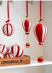 Detail of red and white striped hot air balloon ornaments with glitter on a pine tree