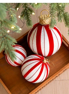 Close-up of red and white striped Christmas ornaments with silver glitter and velvet finish