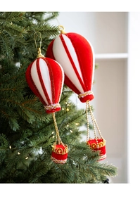 Detail of red and white velvet hot air balloon ornaments hanging on a green Christmas tree
