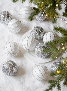 Vista dettagliata delle palline di Natale glitterate argento e perle champagne su neve