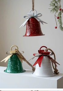 Detail of red, green, and white metal Christmas bells with rustic twine hangers
