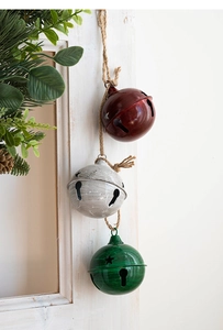 Detalle de campanas navideñas de metal en rojo, blanco y verde con recortes de estrellas