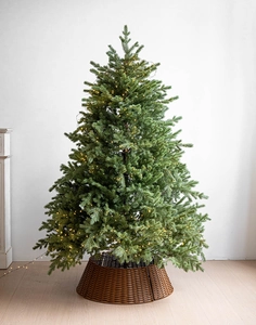 Détail du pied de sapin tressé à la main en rotin marron avec texture et lumières LED