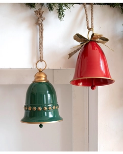 Close-up of vintage red and green metal bells with gold floral motifs and rustic jute ropes