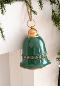 Close-up of a green and gold vintage Christmas iron bell hanging by a fireplace