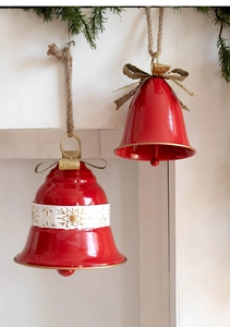 Detail of red metal Christmas bells with white snowflake patterns and golden bows