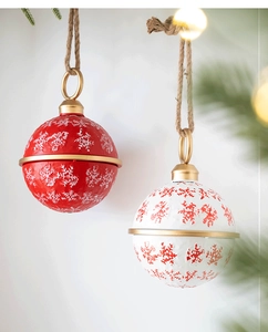 Macro shot of red and white Christmas bells with embossed snowflakes and jute rope