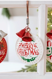 Close-up of metal Christmas door sign with red bells and Merry Christmas text