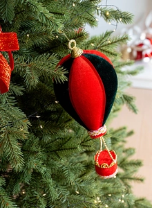 Detail van rood en groen fluwelen luchtballon ornament met gouden kralenketting accenten