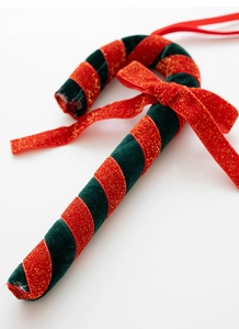 Detailopname van fluwelen kerstzuurstok met een rode glitterstrik en decoratief lint