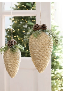Close-up of golden glitter pinecone ornament with snow details for Christmas tree decor