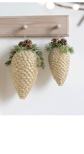 Close-up of sparkling gold pinecone ornaments with green pine needles and rustic twine