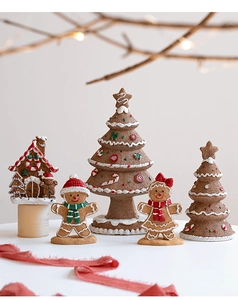 Close-up of resin gingerbread house and Christmas tree set with sugary frost texture