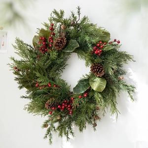 Lush forest style Christmas wreath with pine branches, red berries and natural pine cones