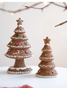 Detail of two resin gingerbread Christmas trees with frosting texture and star toppers