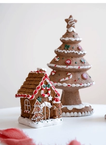 Macro detail of resin gingerbread house and Christmas tree holiday table ornaments