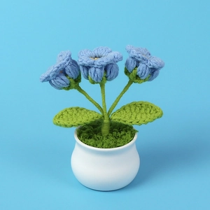 Detail of handmade crochet blue lily of the valley flowers in a white ceramic pot