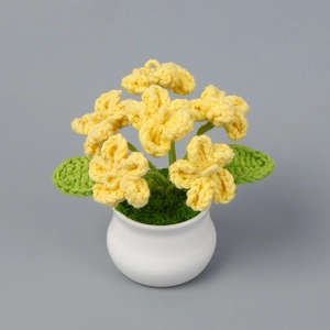 Macro di fiori gialli fatti a mano all'uncinetto in vaso bianco con trama a maglia definita