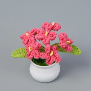 Dettaglio di fiori di non ti scordar di me all'uncinetto in vaso di ceramica bianca