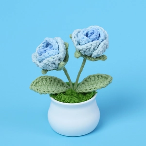 Handmade crochet potted blue roses with green leaves in a white ceramic base