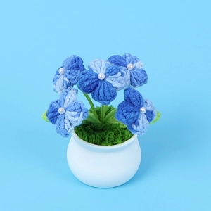 Detail of crochet blue hydrangea plant with white pearls in a ceramic pot