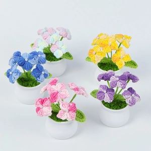 Close-up of five colorful handmade crochet hydrangea potted flowers with pearl details