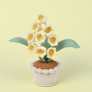 Detail of handmade crochet lily of the valley with yellow petals and pearl stamen