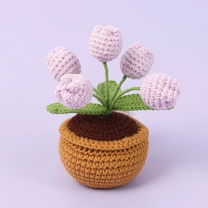 Detail of handmade crochet tulip night light in purple yarn with knit soil and pot