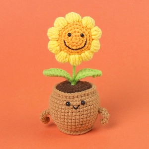 Close-up of handmade crochet sunflower plant with cute smiley face on the pot