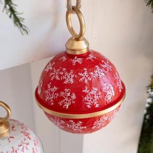Detail of red Christmas iron bell with white snowflakes and natural jute hanging rope