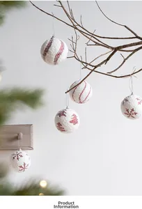 Close-up of white foam Christmas balls with red glitter snowflakes and tree patterns