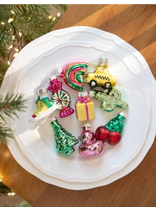 Macro shot of 9 mini glass ornaments including rainbow and taxi on white ceramic plate