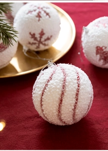 Detail of 8cm red and white Christmas foam ball featuring snow texture and snowflake patterns
