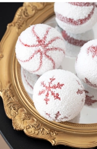 Macro detail of 8cm red and white snowy Christmas balls with snowflake and swirl patterns